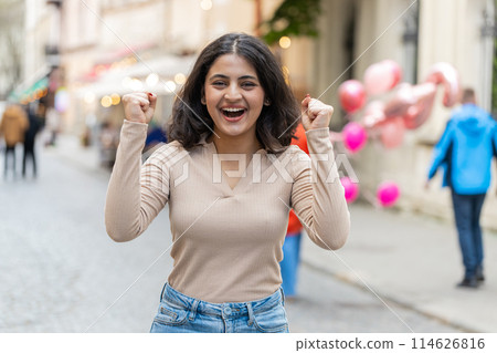 Indian woman looking surprised at camera shocked by sudden win good victory news, wow in city street 114626816