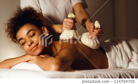 Thai herb compress massage. Woman relaxing in beauty spa, lying with closed eyes 114704708