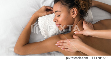 Girl enjoying shoulder massage in the health spa, top view 114704868