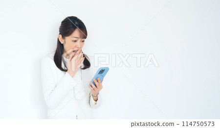 Surprised middle woman looking at smartphone 114750573