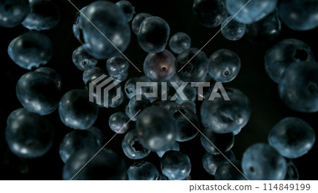 Fresh pieces of blueberries falling into water, top down view, black background 114849199