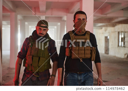 An abandoned building serves as the stronghold for a team of terrorists, fiercely guarding their occupied territory with guns and military equipment 114978462