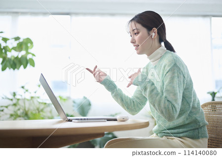 A woman in her twenties having an online meeting in the living room 114140080