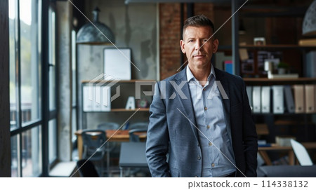 Portrait of a distinguished senior man in a smart casual outfit standing in an office setting 114338132