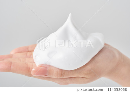 A woman's hand placing a small ball of foam on her palm 114358068