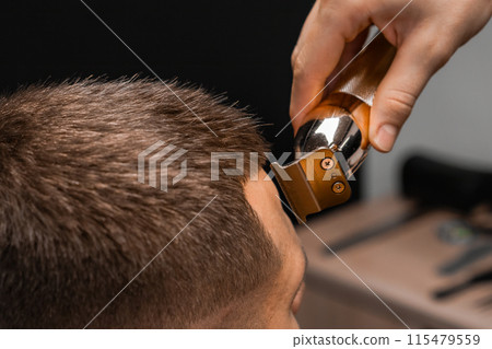 Close up hairdresser shapes mans hair on the forehead.  115479559