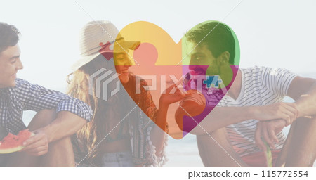 Image of colourful puzzle pieces heart over happy friends at summer beach party 115772554