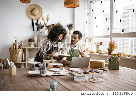 Portrait of mature man and young curly woman creating online catalogue. 115158960