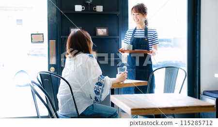 A female cafe clerk serving customers 115285712