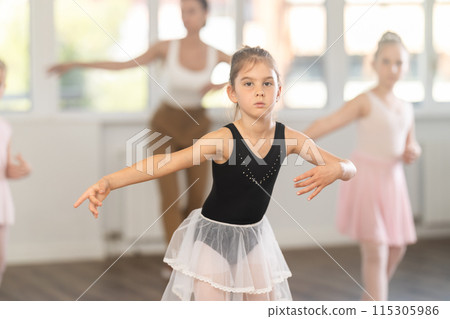 Girls in ballet class perform forth position with correction of female mentor 115305986