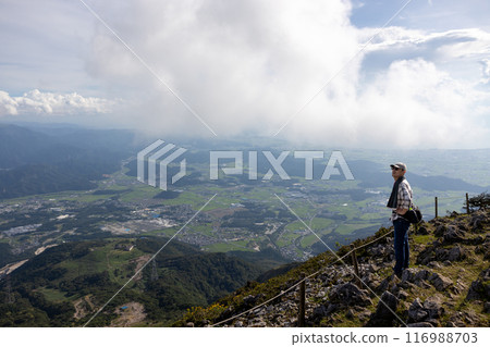 Senior man wearing a hat and towel climbing Mt. Ibuki and looking at the view 116988703