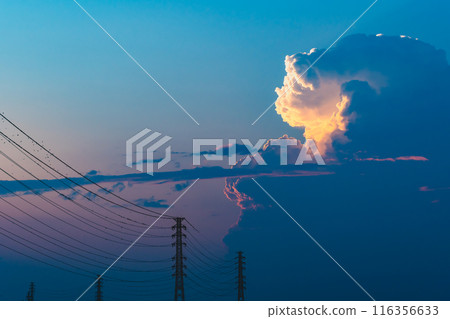 Evening cumulonimbus clouds rising above a power transmission tower b-2 High saturation 116356633