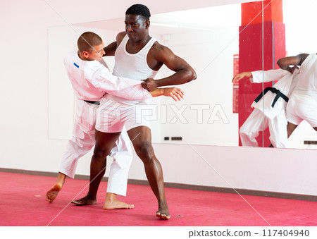 Man training throws on trainer during judo training 117404940