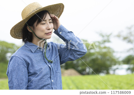 Farmer woman with a headache 117586009