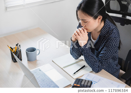 Businesswoman sitting at desk on couch in workplace  117896384