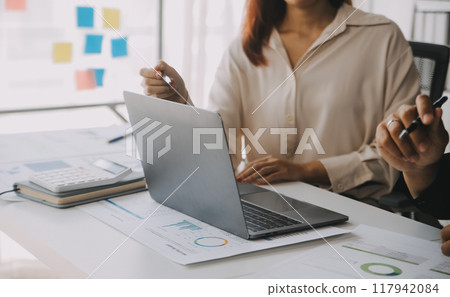 Financial analysts analyze business financial reports on a digital tablet planning investment project during a discussion at a meeting of corporate showing the results of their successful teamwork. 117942084