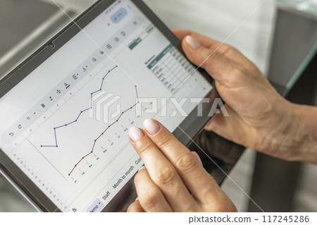 Close up shot of the woman with beautiful hands in the business attire, working on the laptop in the office, making notes 117245286