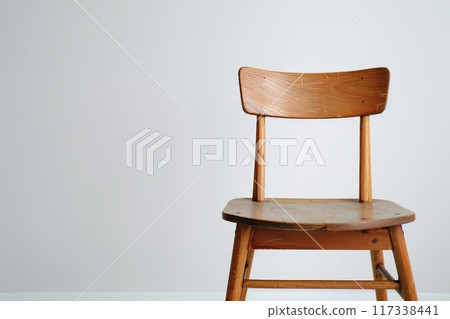 Wooden Chair Against White Wall 117338441