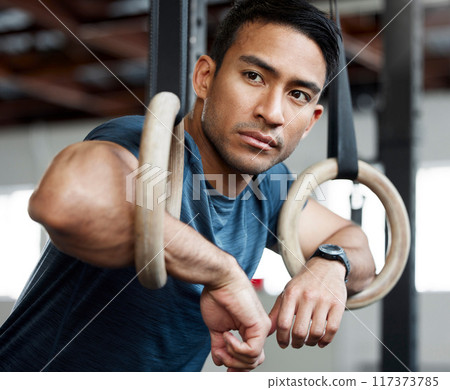 Thinking, gymnastic rings and olympics with a man gymnast hanging on equipment for workout in gym. Idea, fitness and exercise with a male athlete training in gymnastics for health or power 117373785