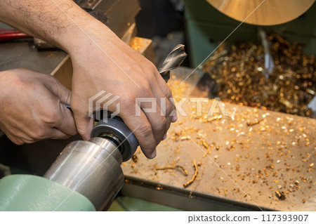 The machine operator set up the drill tool on lathe machine. 117393907