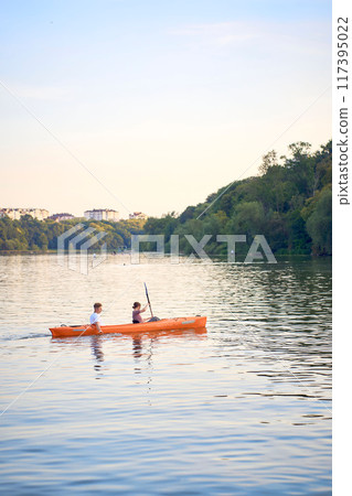 the couple in love kayaking on the river at sunset 117395022