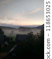 Village in mountains with the view on forest of fir mountains in fog rural vertical 118653025