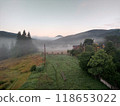 Village in mountains with the view on forest of fir mountains in fog rural horizontal 118653022