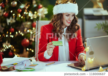 smiling business woman in green office with Christmas tree 118000687