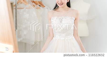 Bride matching and trying on a wedding dress while looking in the mirror 118322632