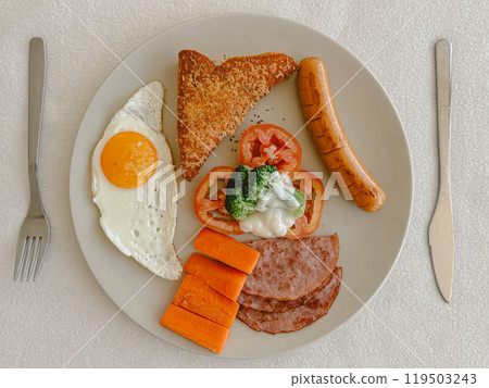 American breakfast sets of fried eggs, toasts, carrots and hams on table. 119503243