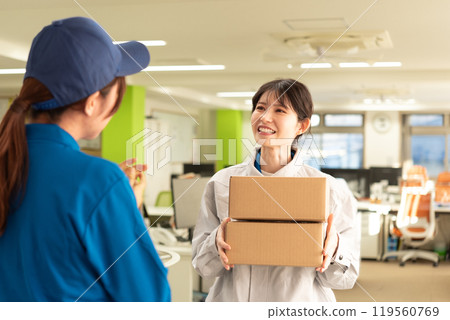 A female engineer in work clothes receiving a parcel 119560769