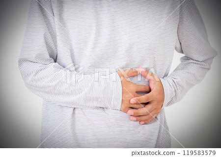 Middle-aged man holding his left abdomen 119583579