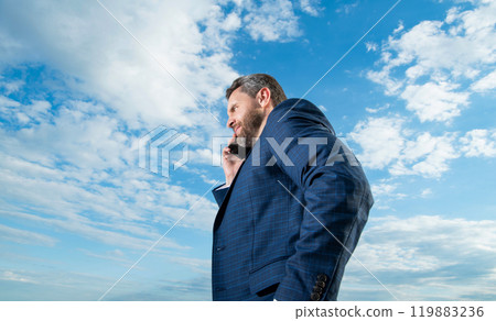 man has phone talk outdoor. man has phone talk wear suit. photo of man has phone talk. 119883236