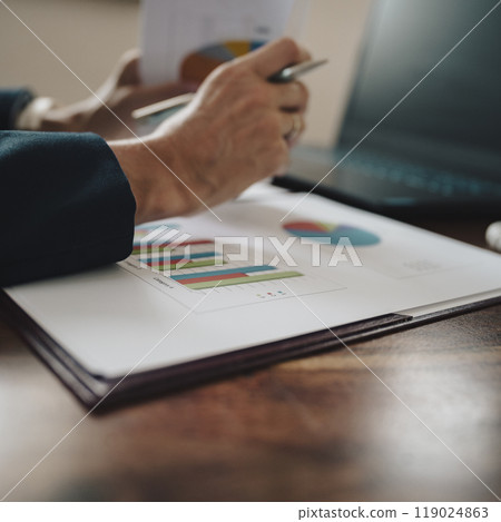 Female hands holding paperwork with statistical financial report on it with graphs and charts 119024863