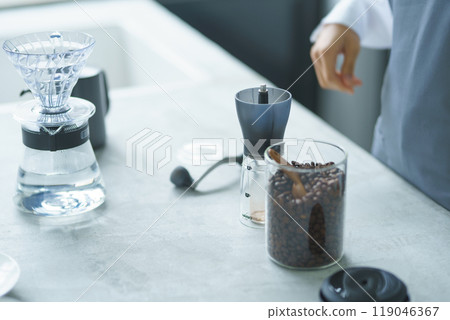 A young female sales clerk brewing coffee on a weekend morning 119046367