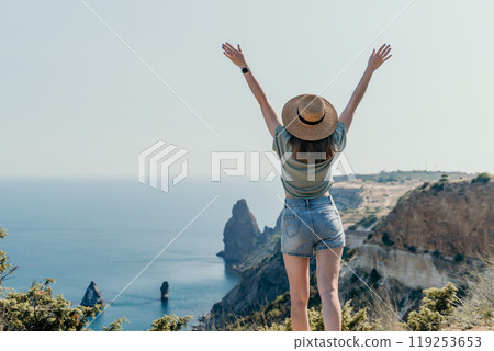 Woman in a Straw Hat Gazing at the Ocean 119253653