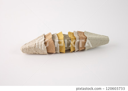 a series of cone-shaped objects made from a rough, fibrous material, egg box recycled paper. cones are arranged in a row, with each cone slightly overlapping the next. creative use of materials. 120603733