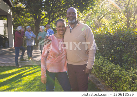 Happy african american couple of senior friends embracing and smiling in sunny garden 120618559