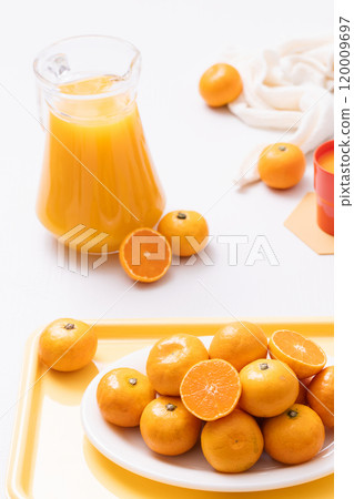 Delicious tangerines plated on a tray and a drink made from tangerines 120009697