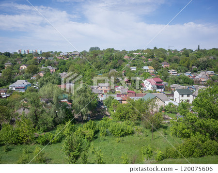 [Ukraine] A rural landscape with houses lined up in the suburban forest as seen from a train window 120075606