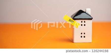 Miniature house with a note Debt. Reminder to pay taxes and rent. Paying off debts for housing and real estate. Copy space 120244198