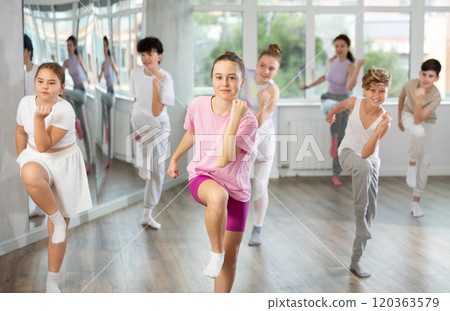 Team of teenagers rehearsing modern dances in dance hall 120363579