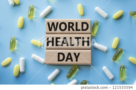 World Health Day symbol. Concept words World Health Day on wooden blocks. Beautiful blue background with pills. Healthcare and World Health Day concept. Copy space. 121533594