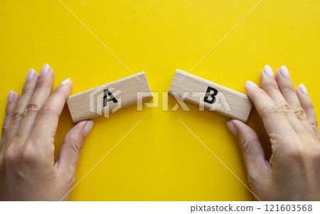 Plan A and Plan B symbol. Concept word Plan A and Plan B on wooden blocks. Businessman hand. Beautiful yellow background. Plan A and Plan B concept. Copy space 121603568