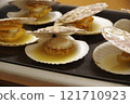 Grilling shelled scallops on a hot plate 121710923