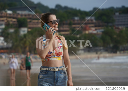 A young woman enjoying a beautiful day at the beach  121809019