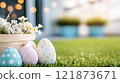 Decorated eggs sit next to a basket of flowers, capturing the joy of Easter festivities on a bright morning. 121873671