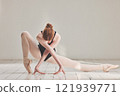 Female ballet dancer in professional ballerina dance posture, dancing or difficult performance in studio rehearsal. Performing artist in point shoes and flexible legs, arms or art technique on floor 121939771