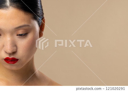 Portrait of asian woman wearing red lipstick on beige background, copy space 121020291