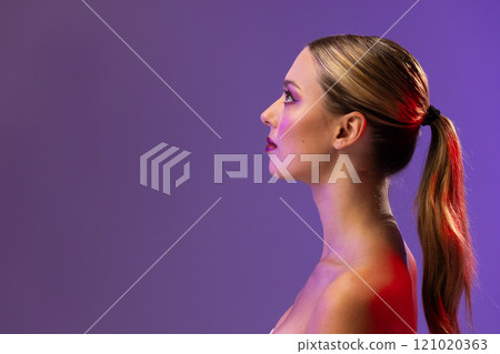 Caucasian woman wearing red lipstick and blue nail polish on purple background, copy space 121020363